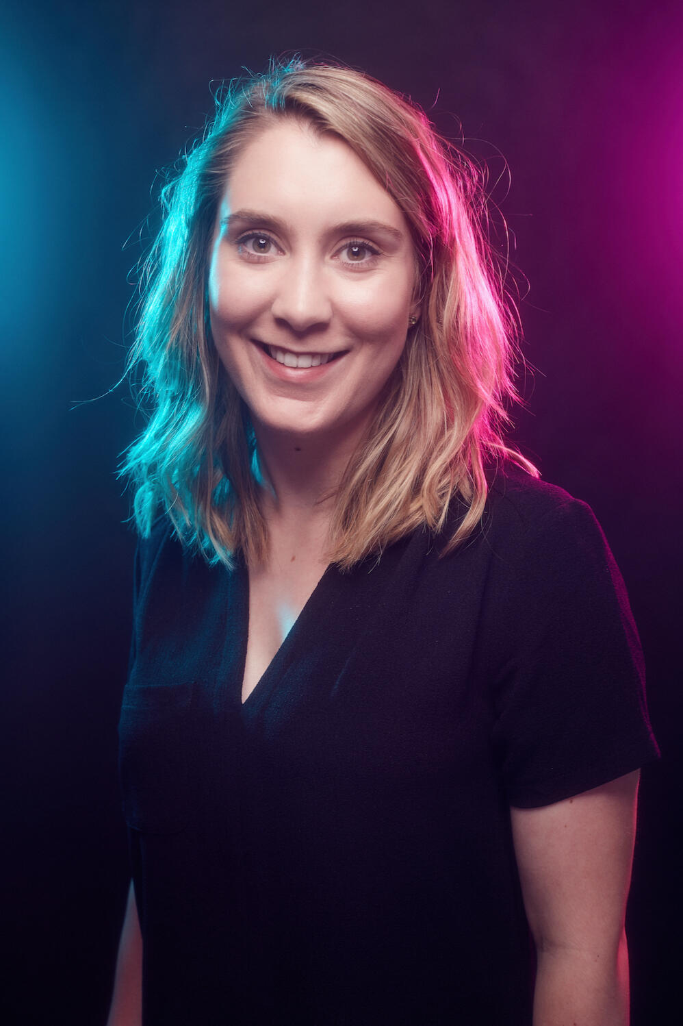 Natasha Profile view of Natasha with blue and pink overhead lights.